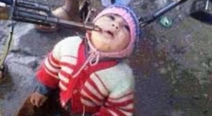 Τρία όπλα σημαδεύουν ένα μικρό παιδί στη Συρία