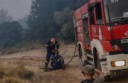 Συγκλονιστική εικόνα από τη φωτιά στην Πάρνηθα: Πυροσβέστης βοηθά εξουθενωμένο συνάδελφό του