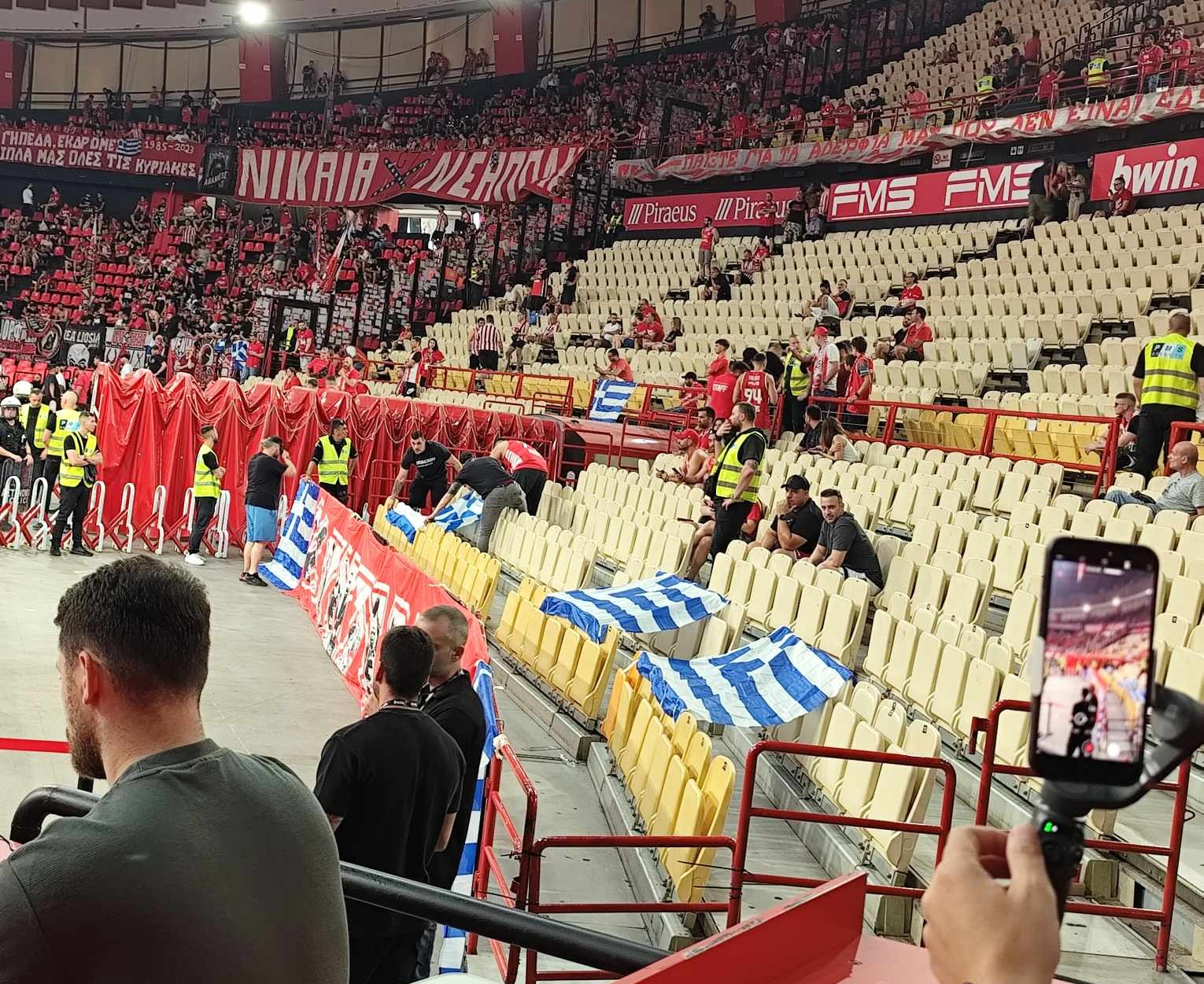Φίλοι του Ολυμπιακού έχουν κρεμάσει ελληνικές σημαίες πίσω από τον πάγκο του Παναθηναϊκού (ΦΩΤΟΓΡΑΦΙΕΣ)